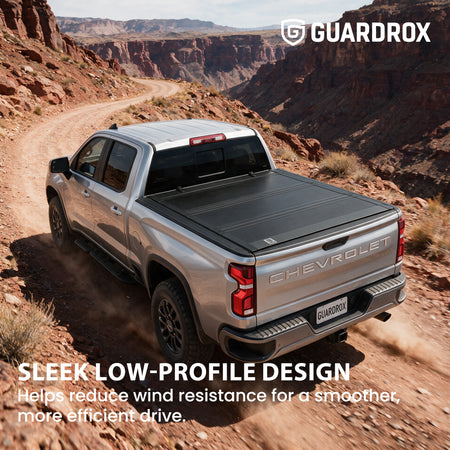 Low profile flip up bed cover riding sleek on a Chevy Silverado 1500 cruising a canyon road for less wind drag