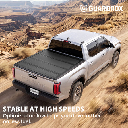 Hard quad-fold tonneau cover riding steady on a Toyota Tundra cruising a mountain highway for better fuel economy