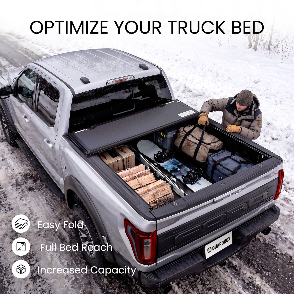 Folding truck bed cover propped open with firewood, skis, and duffels loaded in a snowy pickup bed