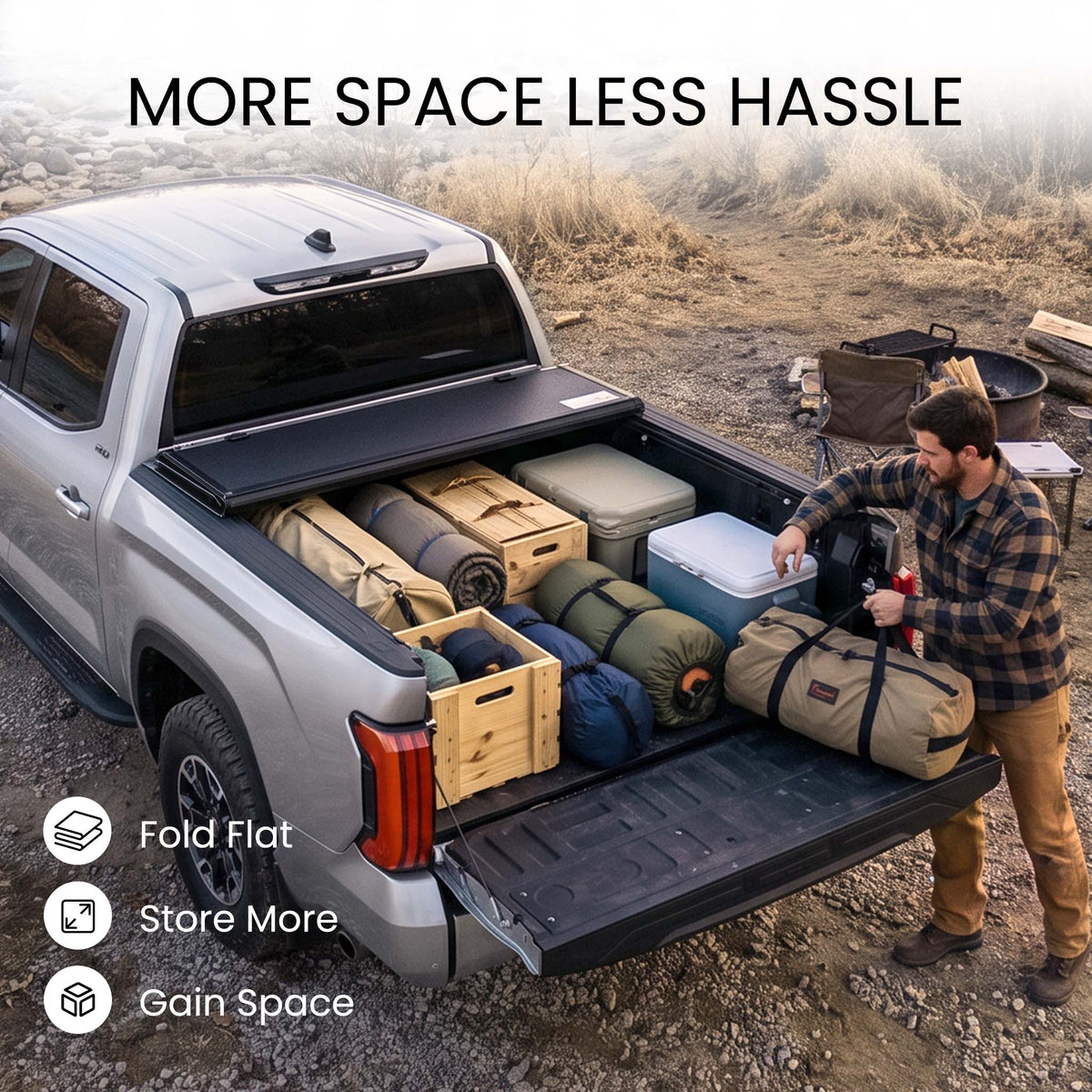 Folding truck bed cover propped open with firewood, skis, and duffels loaded in a pickup bed