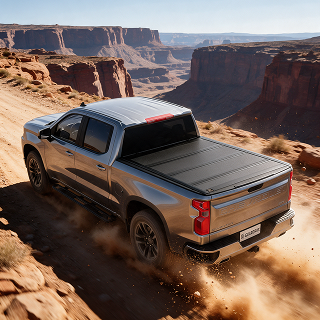 silverado 1500 with a hard quad fold tonneau cover speeding on a gravel mountain road, dust trailing behind