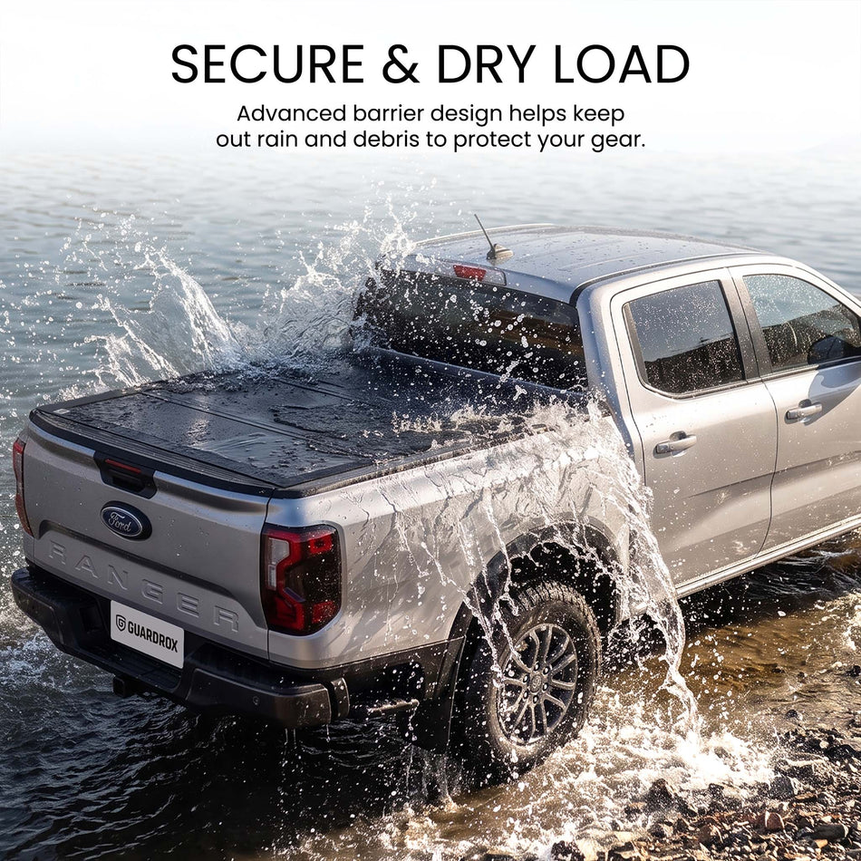 Waterproof hard tri-fold truck bed cover with full-perimeter seals fording a shallow stream