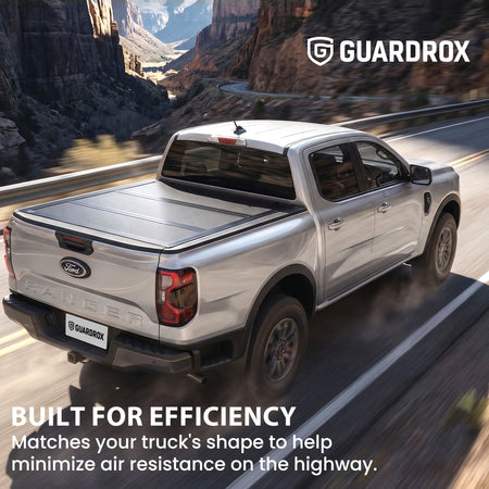 Hard truck bed cover riding steady on a pickup cruising a mountain highway for better fuel economy